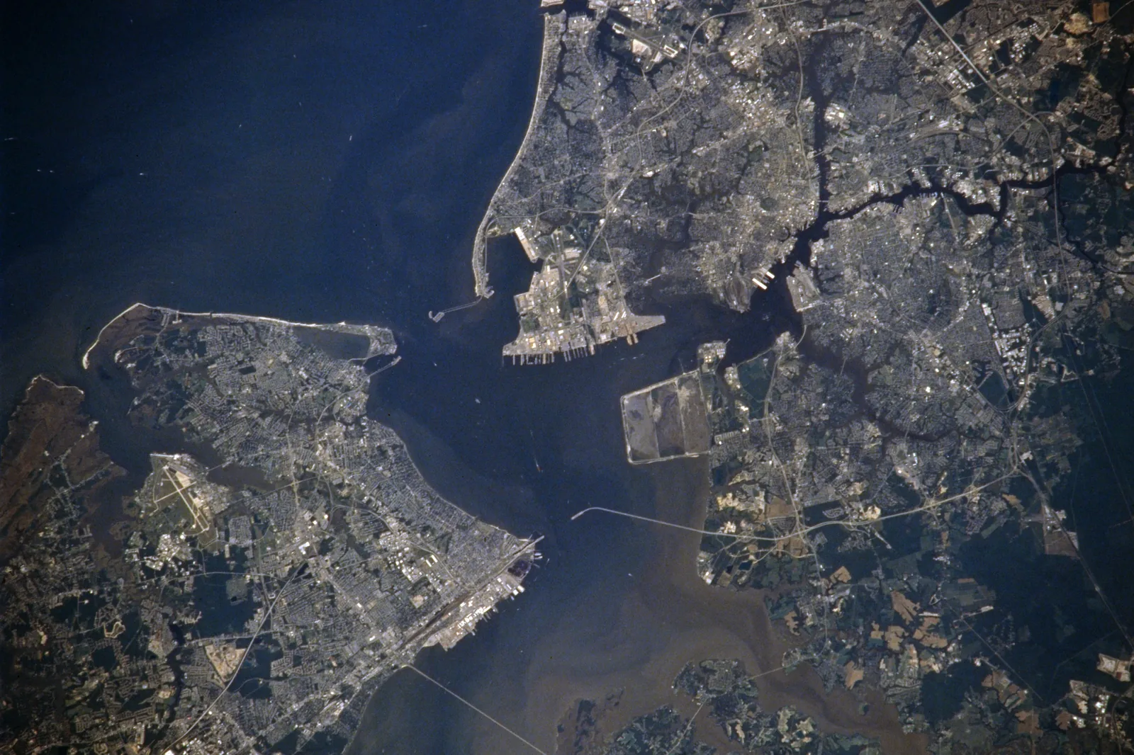 Hampton Roads seen from orbit in July 1996, with Norfolk and Portsmouth on the south side of the harbor and Hampton and Newport News on the peninsula across the water.