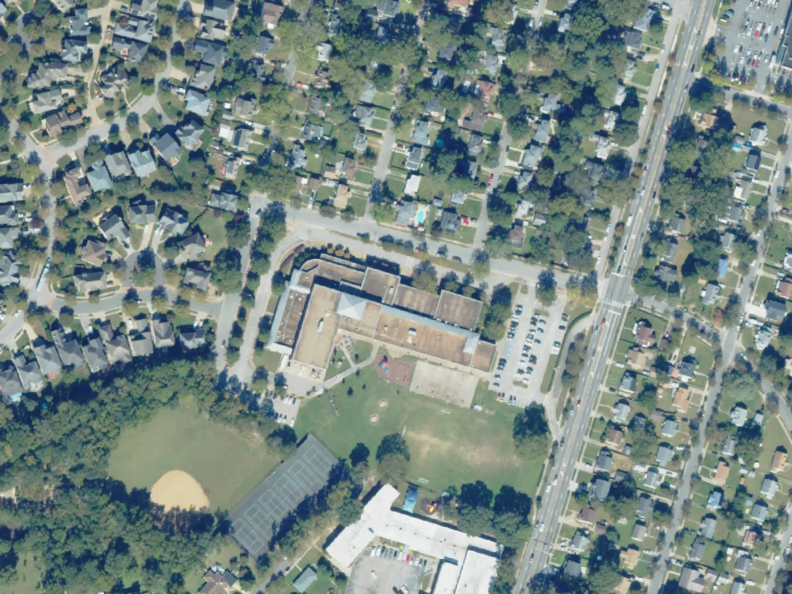 Academy for Discovery at Lakewood and its grounds, center, from the air in October 2023.