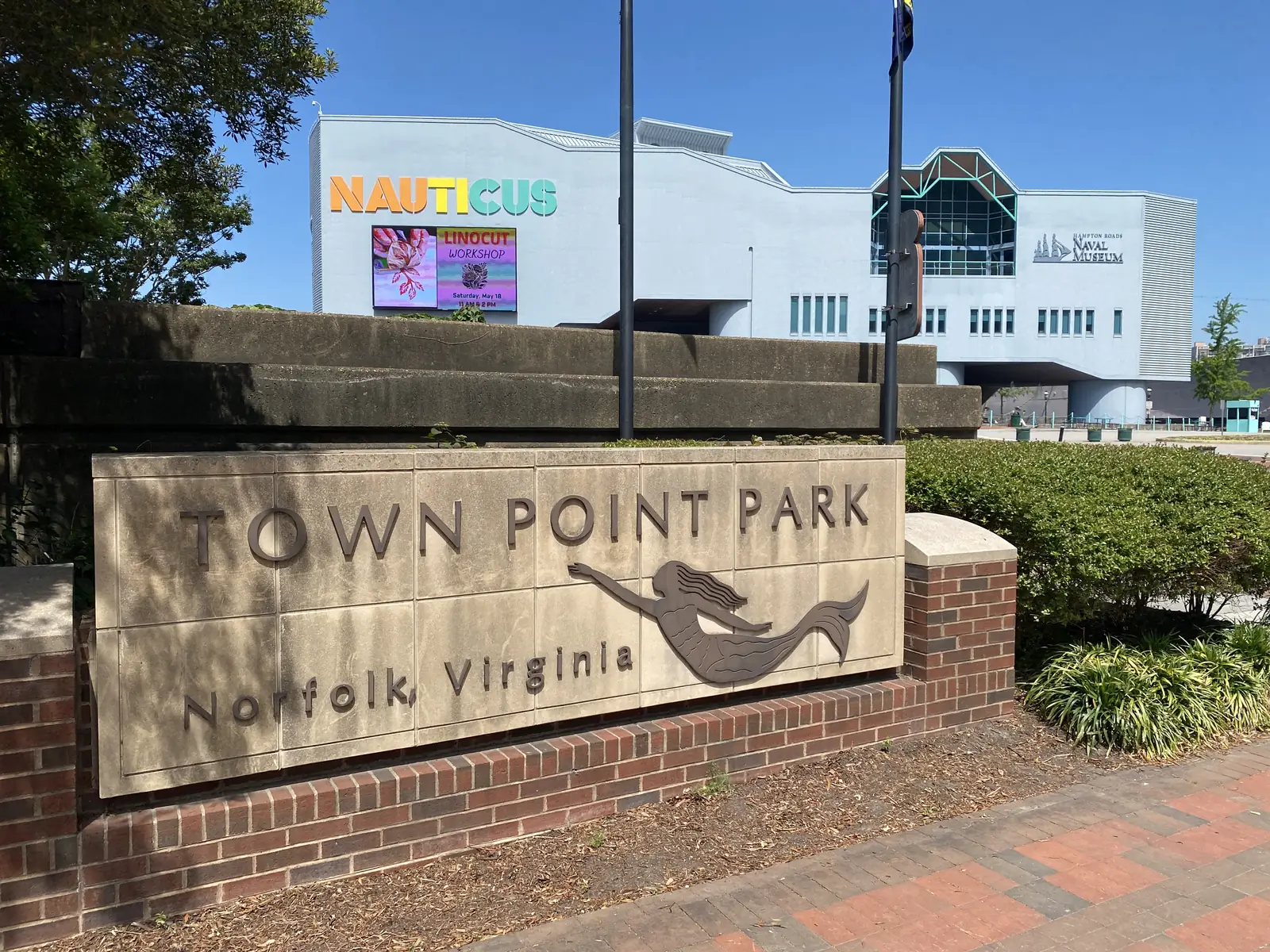 The Town Point Park sign on the downtown Norfolk waterfront, with Nauticus behind it.