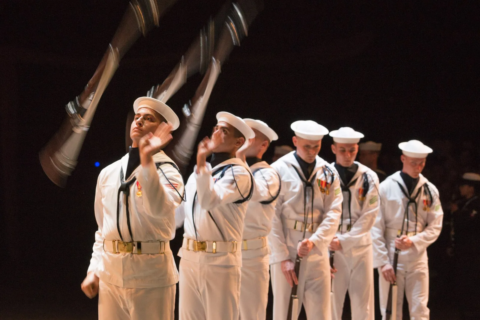 Members of the U.S. Navy Ceremonial Guard Drill Team spin their rifles during the Virginia International Tattoo at Scope Arena in Norfolk.