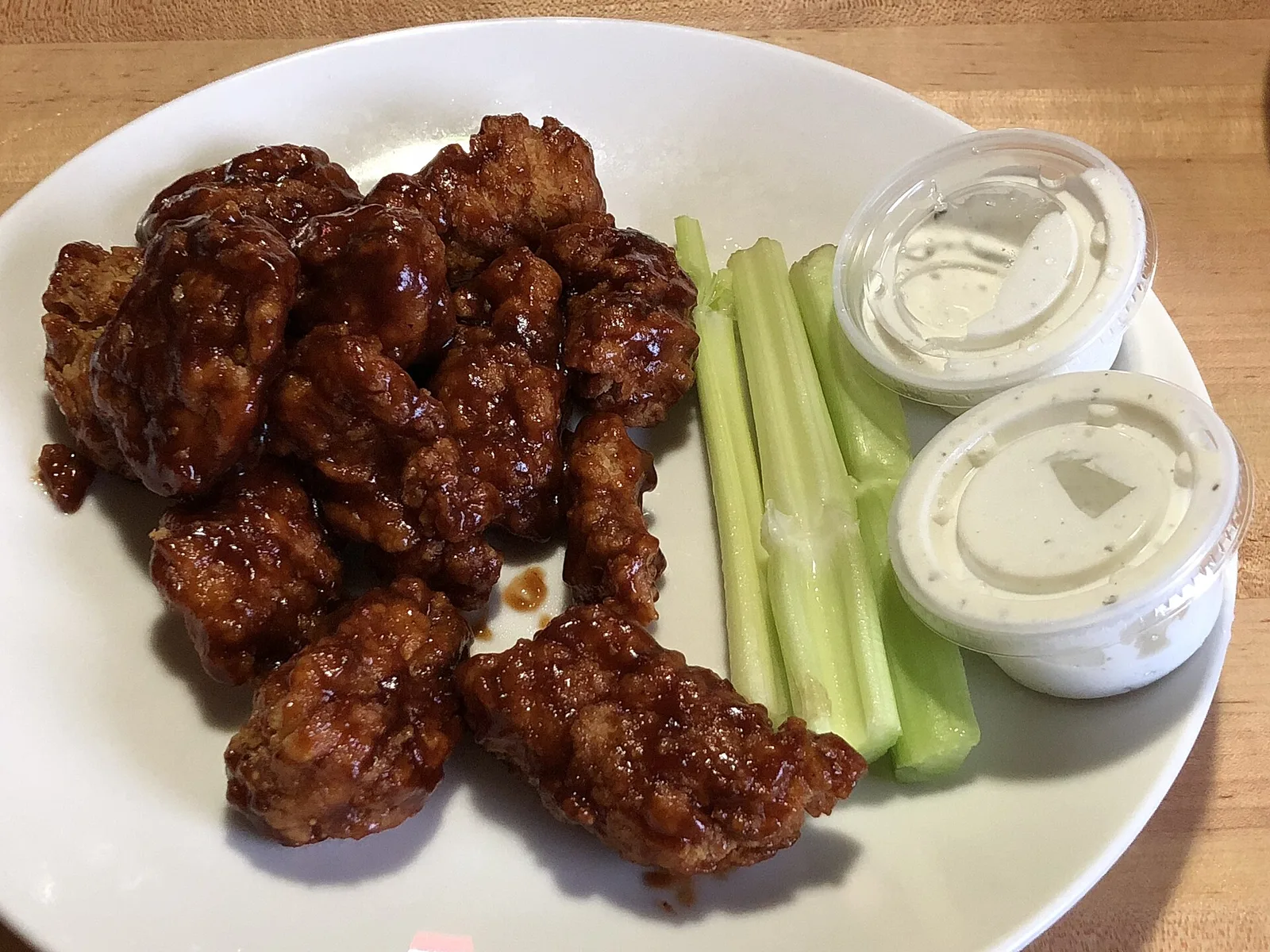 A plate of honey barbecue boneless wings with celery and ranch dressing. The photo was not taken at a Norfolk restaurant.